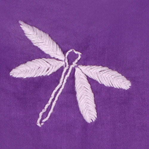 Embroidered dragonfly design on a purple fabric background