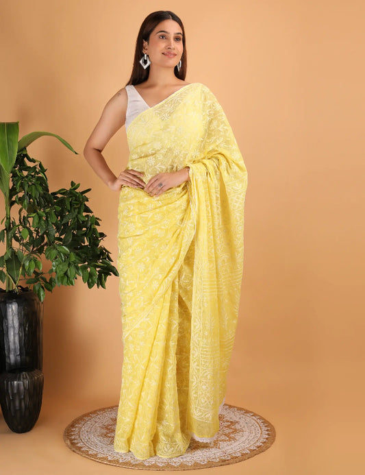 Woman wearing a yellow Hand Embroidered Chikankari saree with a plant on a beige background