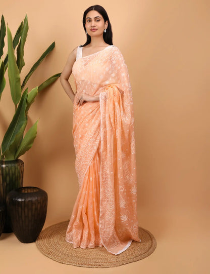 Woman wearing a peach  Hand Embroidered Chikankari saree with a beige background