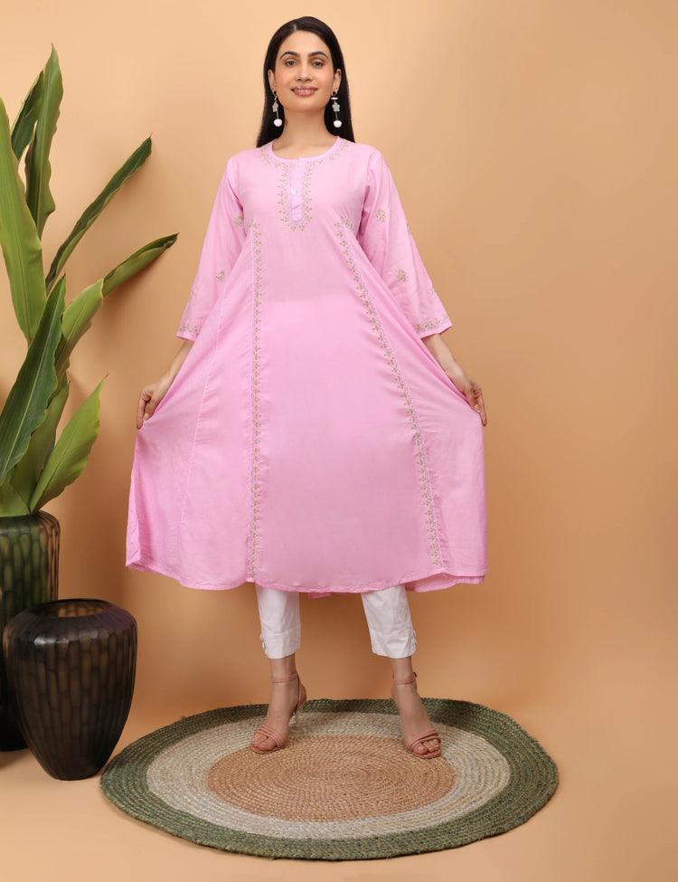 Woman wearing a pink kurta with white pants on a beige background