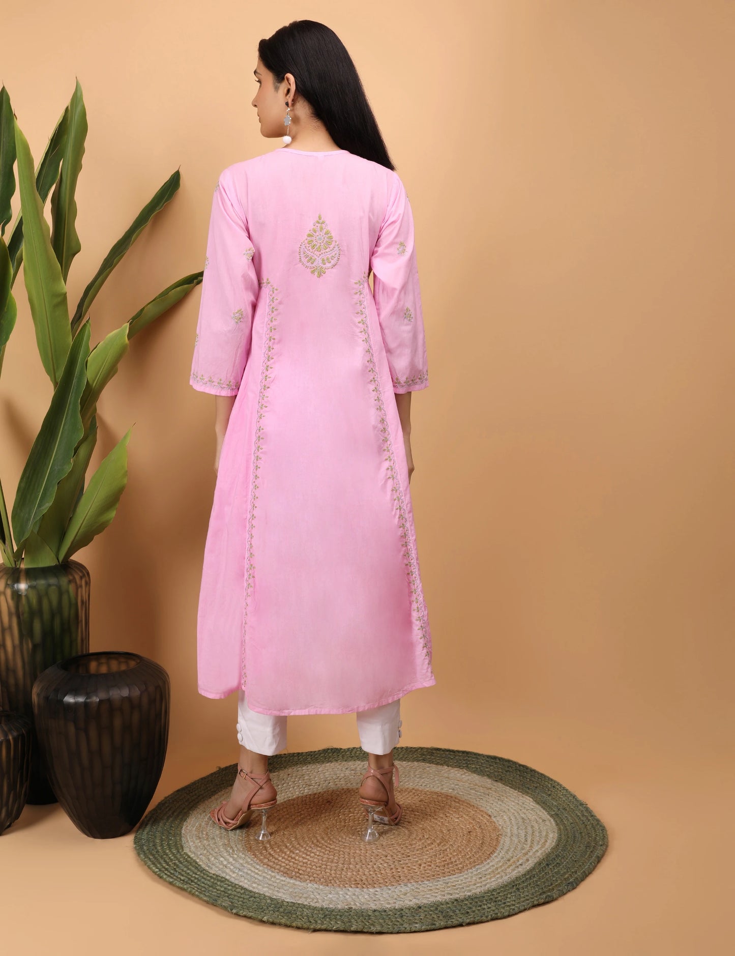 Woman wearing a pink kurta with white pants on a beige background Back Pose