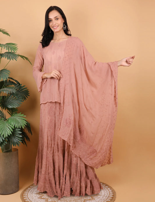 Woman wearing a  hand embroidered chikankari lahenga and choli against a beige background