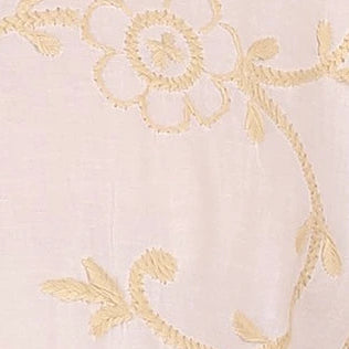 Close-up of gold floral embroidery on a light pink fabric background