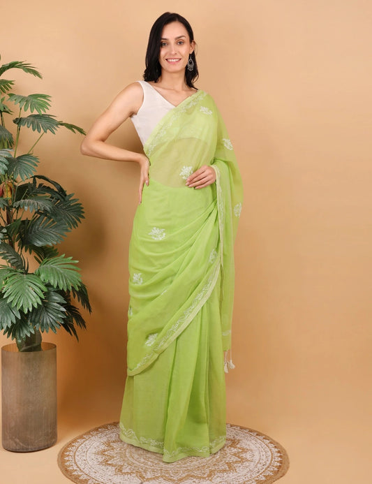 Woman wearing a light green saree with a beige background
