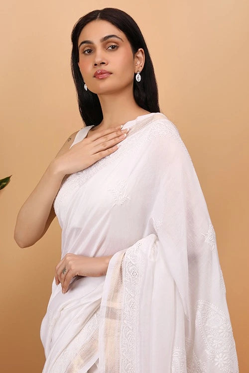 Woman wearing a white HAnd Embroidered Chikankari saree with a beige background