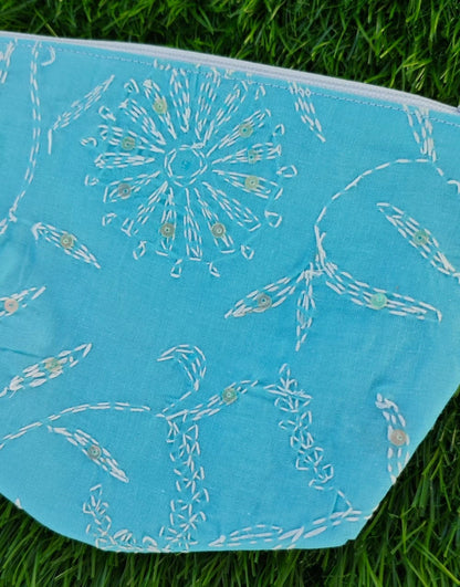Blue fabric with white chikankari patterns on grass