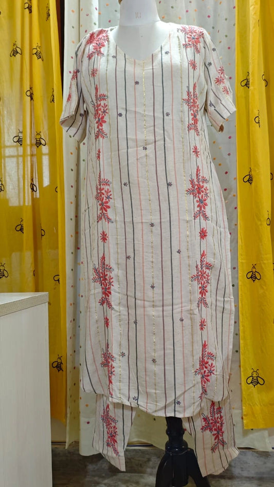 White kurta with red floral  Chikankari embroidery on a mannequin against a yellow curtain background