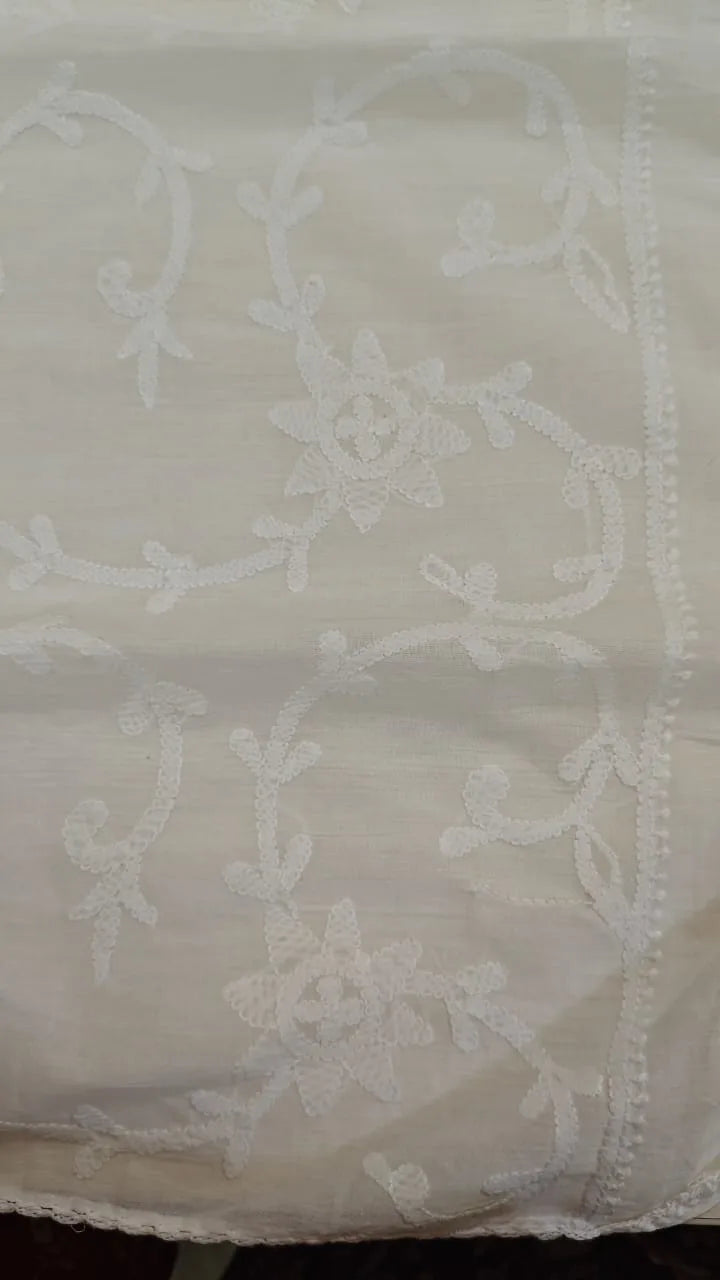 White   fabric with intricate patterns on a plain background