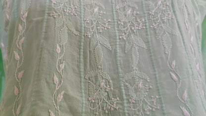 Chikankari Embroidered fabric with floral patterns on a green background